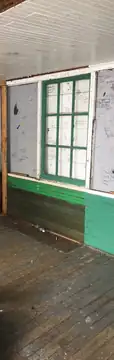 Cabin exterior with broken windows and graffiti